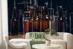 Fototapeta: Butelki i szklanka piwa rzemieślniczego na drewnianym kontuarze