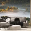 Fototapeta: Dreamy panoramic misty landscape with trees poking our of foggy