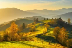 Fototapeta: Jesienny krajobraz z górami o wschodzie słońca