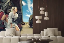 Fototapeta: Kobieta w zabytkowe sukienka siedzi na koła lokomotywy.