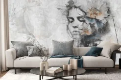 Fototapeta: Kobieta z kwiatem na głowie na szarej ścianie