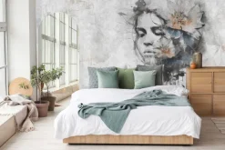 Fototapeta: Kobieta z kwiatem na głowie na szarej ścianie