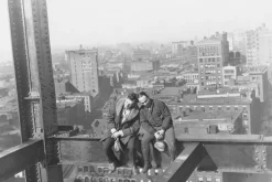 Fototapeta: Mężczyźni na metalowej konstrukcji na tle miasta