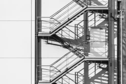 Fototapeta: Metalowe zewnętrzne schody na białej ścianie