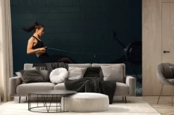 Fototapeta: Side view of young muscular woman exercising in gym with rowing