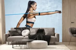Fototapeta: Silna kobieta używająca oporu podczas wykonywania ćwiczeń. zdjęcie