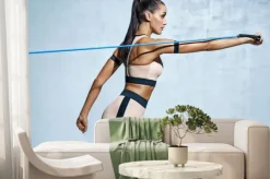 Fototapeta: Silna kobieta używająca oporu podczas wykonywania ćwiczeń. zdjęcie