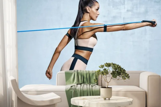 Fototapeta: Silna kobieta używająca oporu podczas wykonywania ćwiczeń. zdjęcie