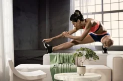 Fototapeta: Sport. kobieta na siłowni robi ćwiczenia rozciągające i uśmiecha