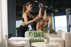 Fototapeta: Sporty girl doing weight exercises with the help of her personal