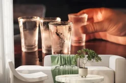 Fototapeta: Strzał kieliszek wódki w ręce na drewnianym stole.