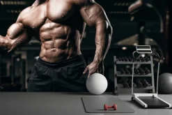 Fototapeta: Umięśniony kulturysta trenuje na siłowni