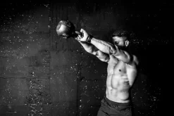 Fototapeta: Umięśniony mężczyzna trenujący z kettlebell