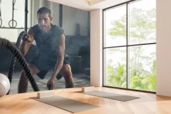 Fototapeta: Umięśniony mężczyzna ćwiczy z liną