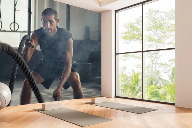 Fototapeta: Umięśniony mężczyzna ćwiczy z liną