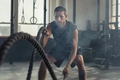 Fototapeta: Umięśniony mężczyzna ćwiczy z liną