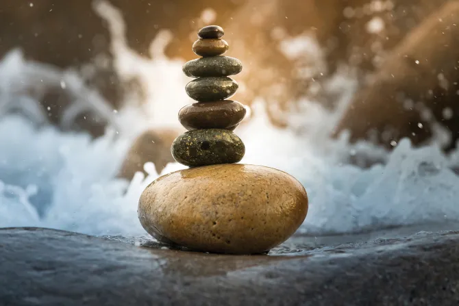 Fototapeta: Wieża z kamieni na tle wody