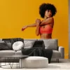 Fototapeta: Young fit black woman in sportswear posing isolated on yellow