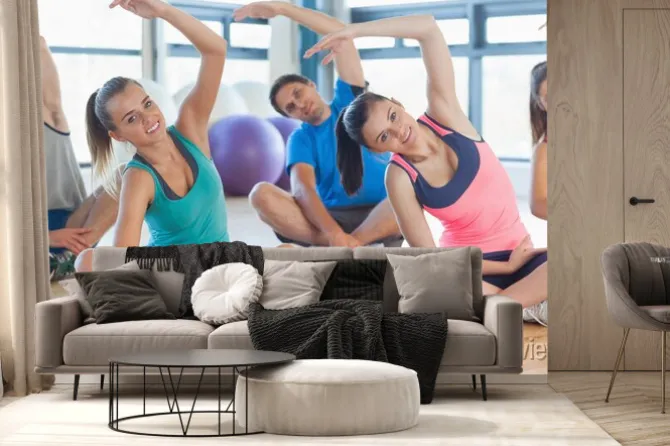 Fototapeta: Zajęcia fitness i instruktor siedzi i rozciągając ręce