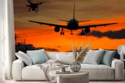 Naklejka: Dron i lądujący samolot o zachodzie słońca