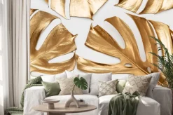 Naklejka: Golden monstera leaves on white background