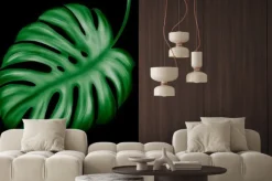 Naklejka: Tropical leaves of green color on a dark background.