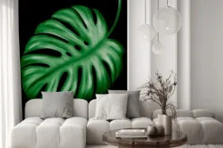 Naklejka: Tropical leaves of green color on a dark background.