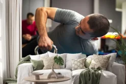 Naklejka: Young man podnoszenia hantle i kettlebell w centrum fitness