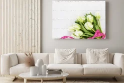 Obraz: Białe tulipany ozdobione czerwoną wstążką na białym obrusem.