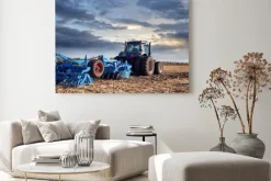 Obraz: Ciągnik pracuje w polu o zachodzie słońca