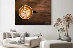 Obraz: Kubek gorącego cappucino stoi na drewnianym stole.