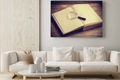 Obraz: Loupa i książka na drewnianym stole