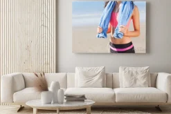 Obraz: Połowy sekcji zdrowej kobiety z ręcznikiem na szyi na plaży