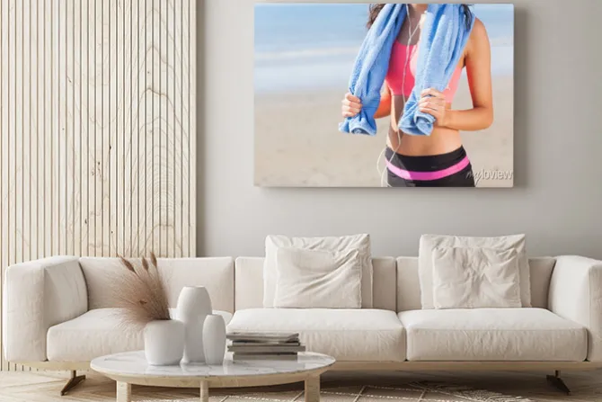 Obraz: Połowy sekcji zdrowej kobiety z ręcznikiem na szyi na plaży