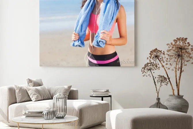 Obraz: Połowy sekcji zdrowej kobiety z ręcznikiem na szyi na plaży