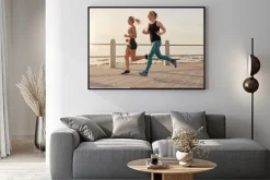 Plakat: Młode kobiety biegnące wzdłuż nadmorskiej promenady