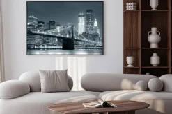 Plakat: Most brookliński na tle czarno-białych wieżowców