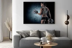 Plakat: Muskularna kobieta w studio na ciemnym tle