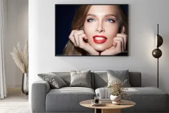 Plakat: Piękna dziewczyna z czerwonymi ustami z rękami w pobliżu twarzy