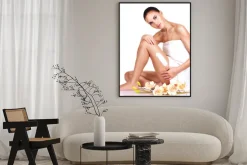 Plakat: Piękna młoda kobieta przy użyciu kremu.