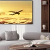 Plakat: Samolot na niebie o zachodzie słońca