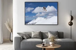 Plakat: Snowboardzista skaczący w górach