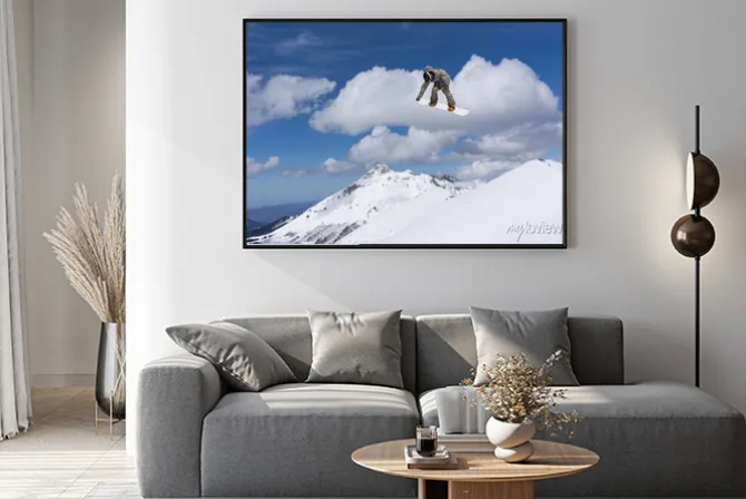 Plakat: Snowboardzista skaczący w górach