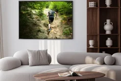 Plakat: Trailrunner z plecakiem uruchomiony po stromym wzgórzu