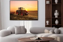 Plakat: Traktor na polu o zachodzie słońca