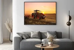 Plakat: Traktor na polu o zachodzie słońca