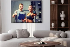 Plakat: Uśmiechnięta młoda kobieta z osobistym trenerem w siłowni