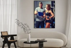 Plakat: Uśmiechnięta młoda kobieta z osobistym trenerem w siłowni