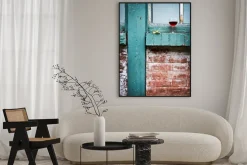 Plakat: Verre de vin rouge sur un bord de fenêtre