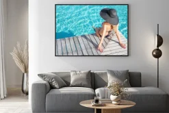 Plakat: Woman sitting on the deck by the pool